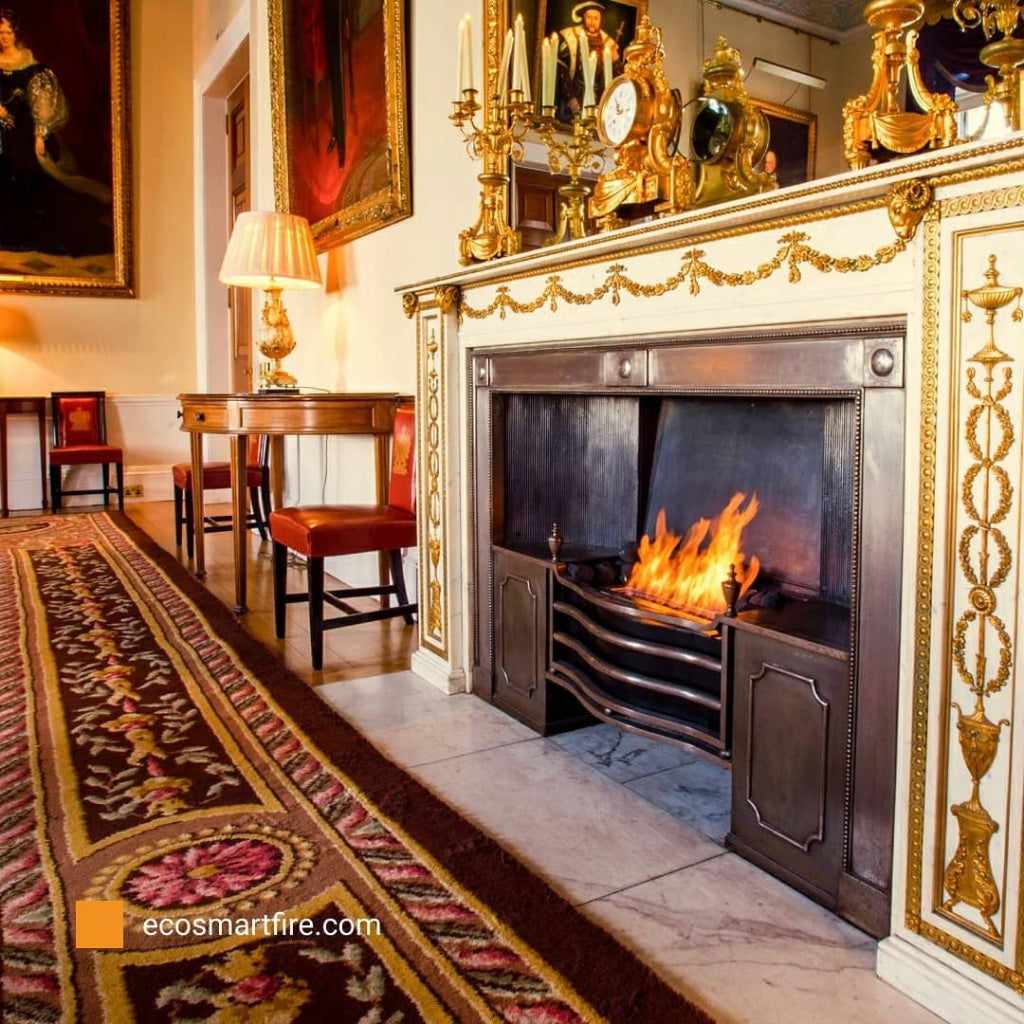 EcoSmart Fire Grate 36 featuring a black metal curved design with a burning flame inside an ornate fireplace.