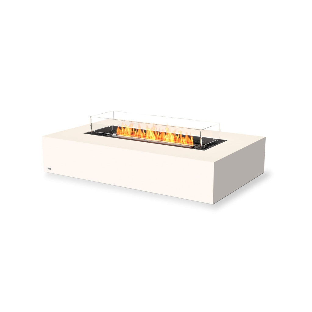 EcoSmart Fire Wharf 65 ethanol fire pit table in white with a central burner, glass screen, and orange flames.