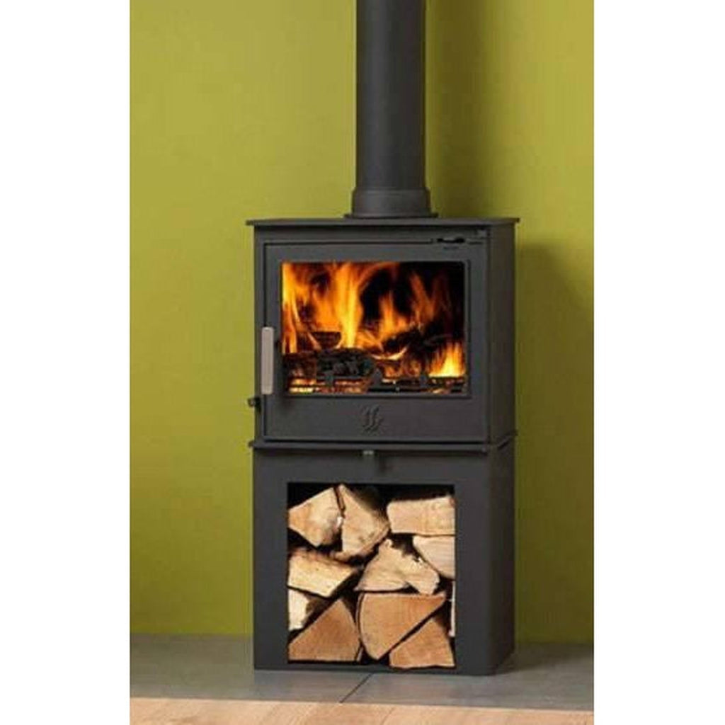 ACR Malvern HD electric stove in black with a log storage base and a glowing flame effect against a green wall.