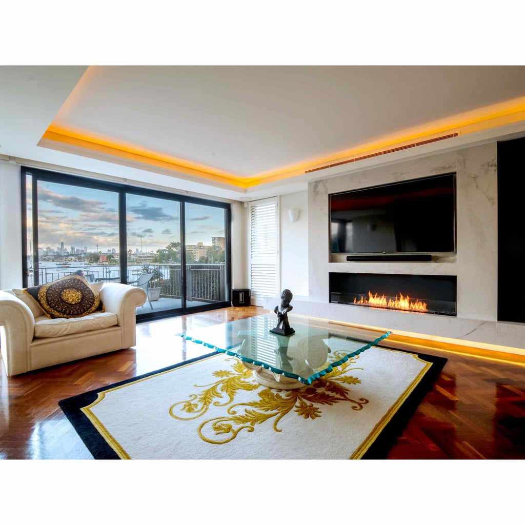 EcoSmart Fire Flex 68 bioethanol fireplace insert set into a white marble wall below a wall-mounted television.
