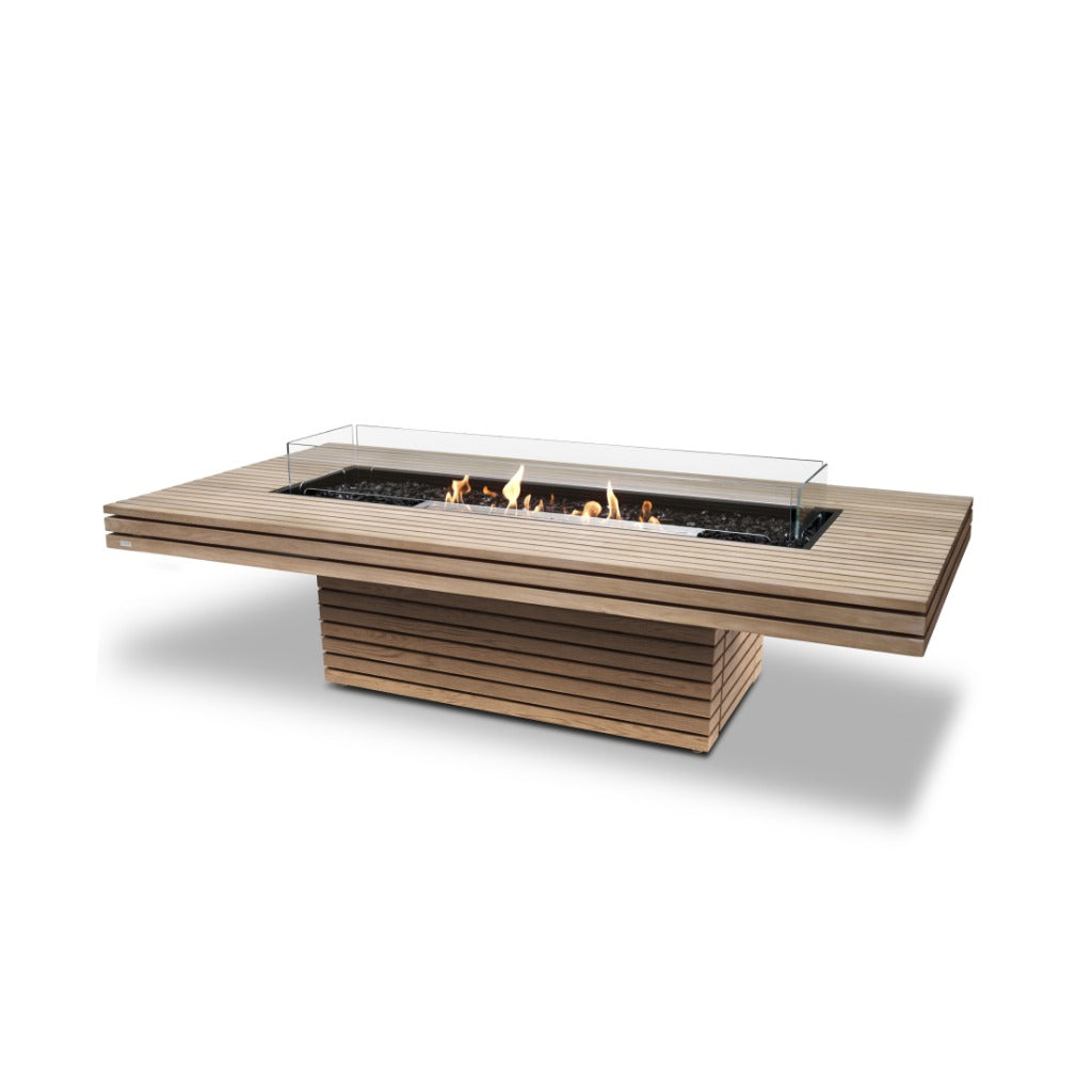 EcoSmart Fire Gin 90 bioethanol fire pit table with a slatted teak wood finish and a glass wind guard.