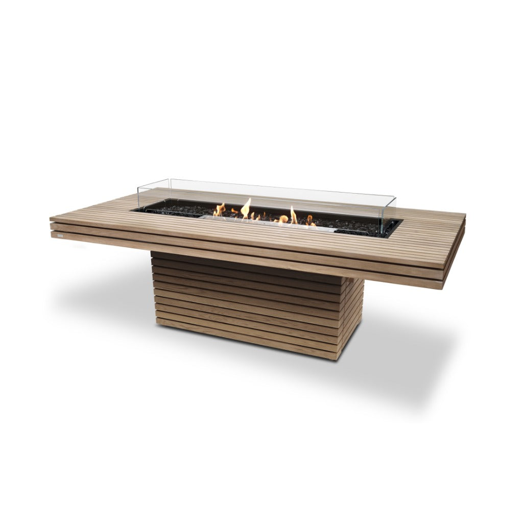EcoSmart Fire Gin 90 dining fire pit table in slatted light wood with a central burner and glass wind guard.