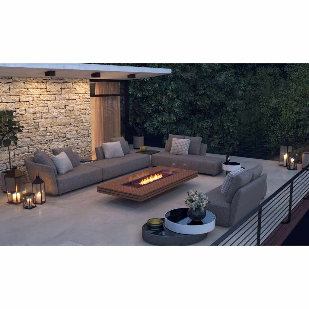 EcoSmart Fire Gin 90 low bioethanol fire pit table with a wooden frame on a modern outdoor terrace at night.
