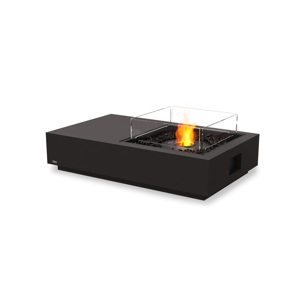 EcoSmart Fire Manhattan 50 bioethanol fire pit table in black with a glass screen and burning flame on black stones.