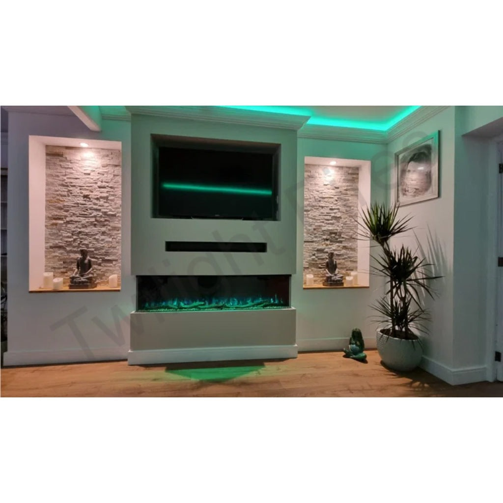 Luvelle 50” 3D panoramic electric fire with green flame effect, set in a white media wall with stone alcoves.