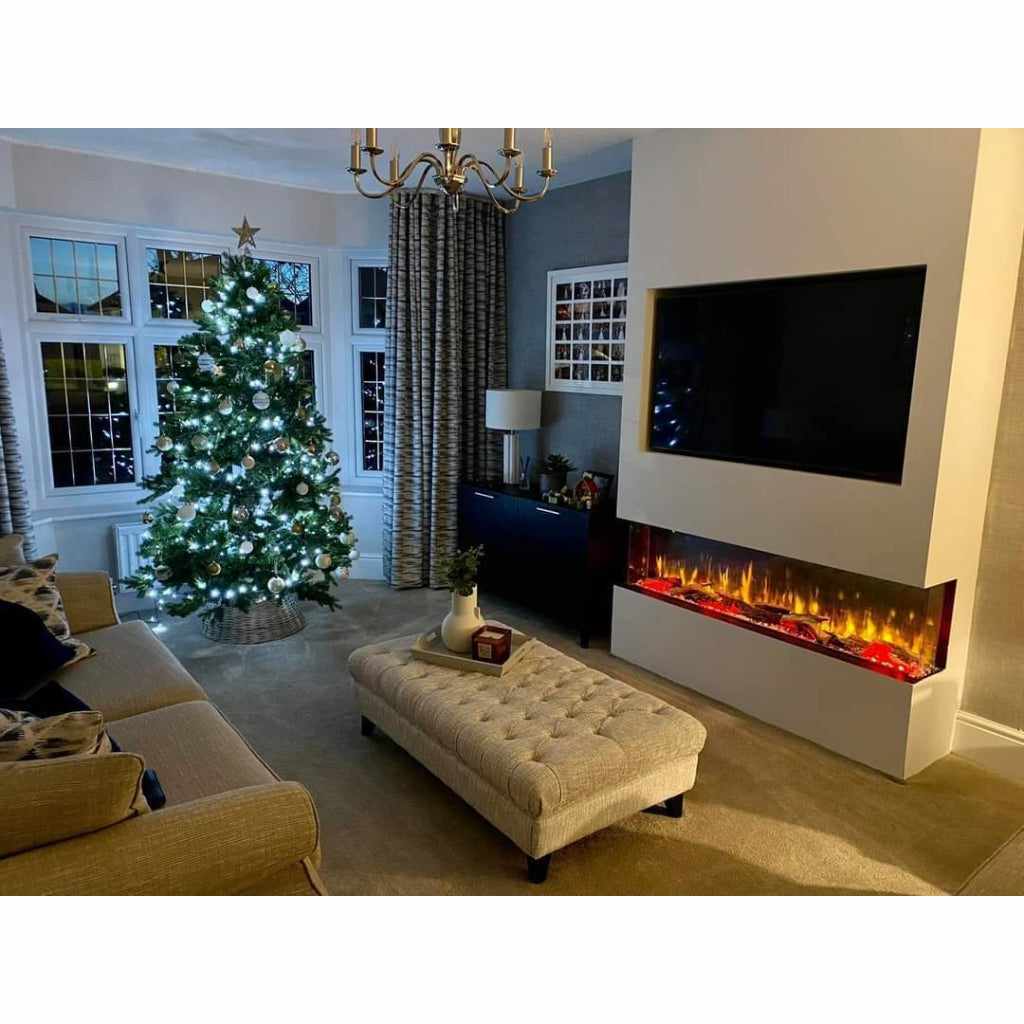 Luvelle 50” 3D panoramic electric fire with glowing orange flames, set in a white media wall below a mounted TV.