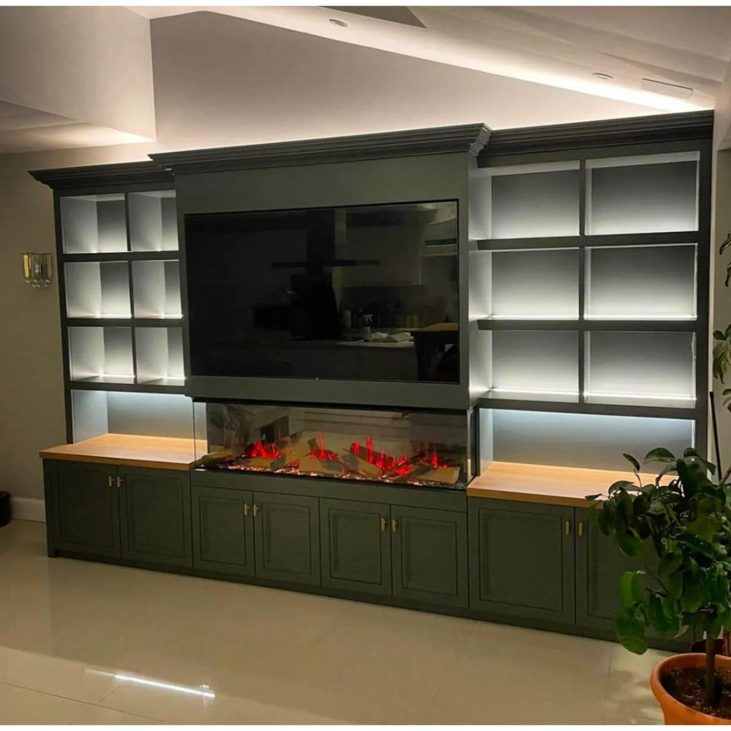 Vision Futura 1300 electric fire in a dark green media wall with illuminated shelving, wooden tops, and a flat-screen TV.