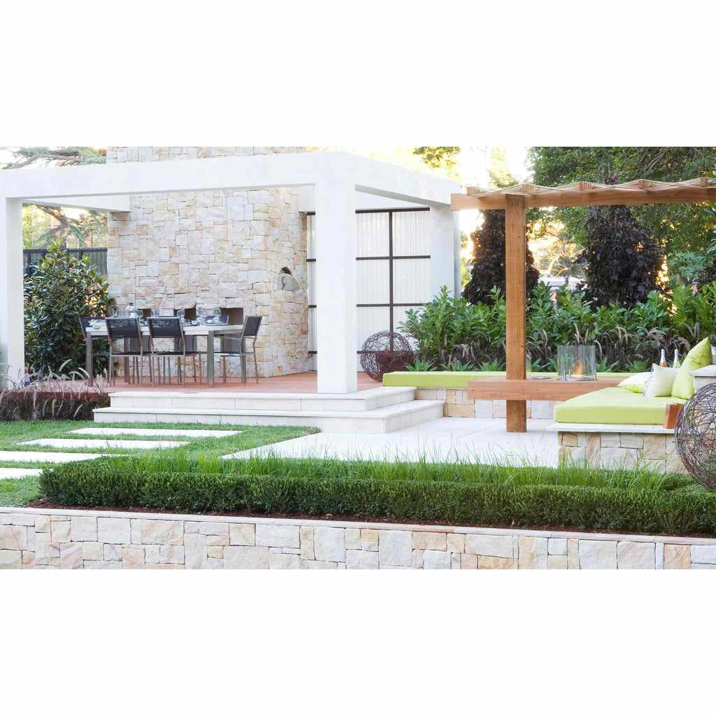 EcoSmart Fire AB3 ethanol burner integrated into a wooden garden bench on a modern stone patio with lime green cushions.