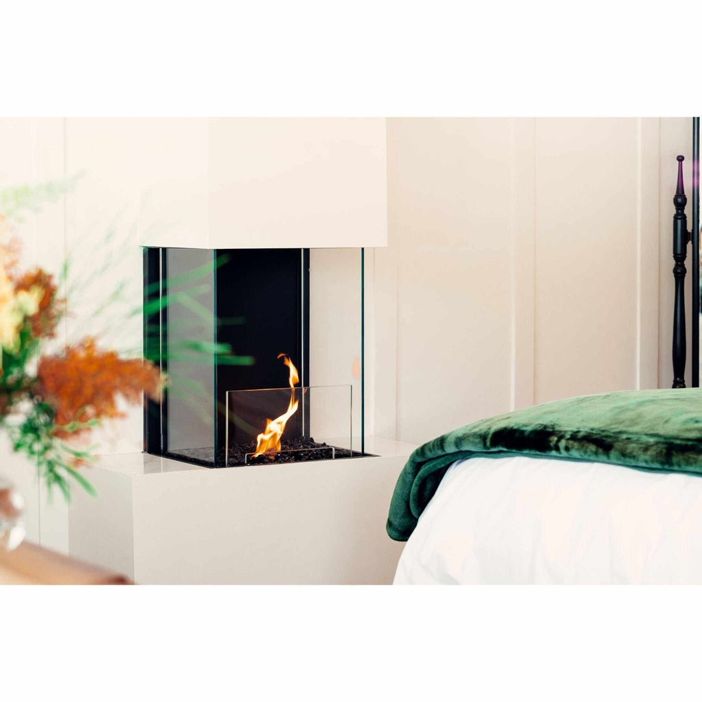 EcoSmart Fire Flex 18 bioethanol fireplace with a black interior and glass surround, set in a white bedroom wall.