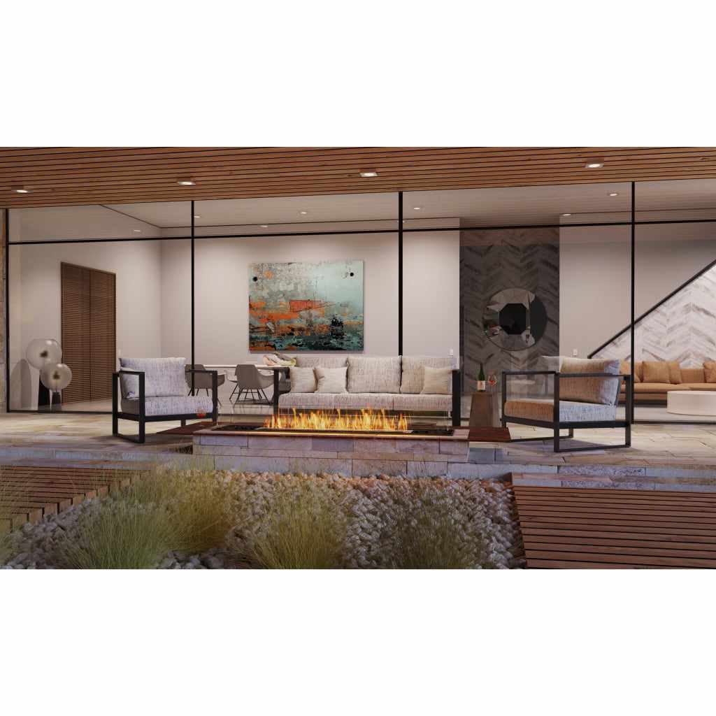 EcoSmart Fire Flex 78 bioethanol fireplace insert with a long flame set in a stone patio with outdoor lounge furniture.