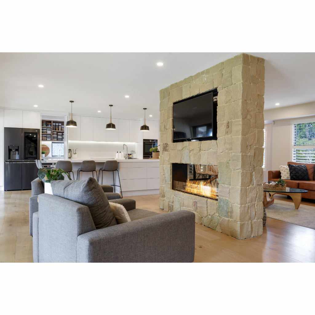 EcoSmart Fire Flex 78 bioethanol fireplace insert set into a rustic stone pillar dividing a modern open-plan room.