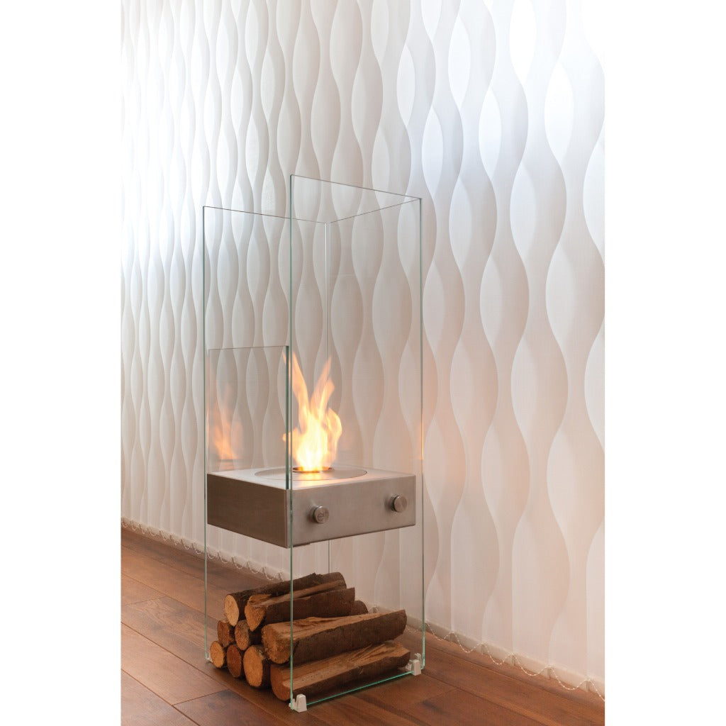 EcoSmart Fire Ghost bioethanol fireplace with a glass frame, stainless steel burner, and logs on a wooden floor.