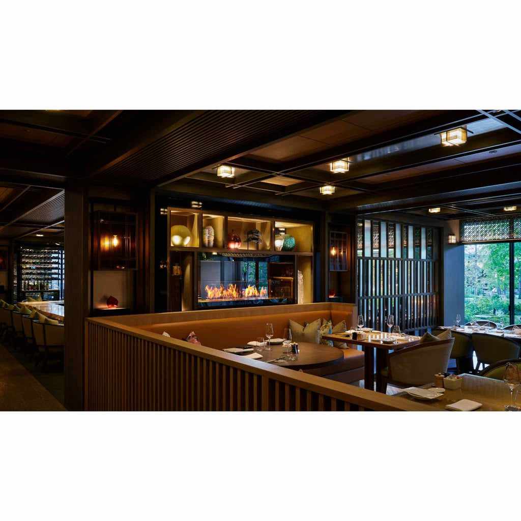 EcoSmart Fire XL1200 ethanol burner integrated into a dark wood restaurant wall with warm ambient lighting.