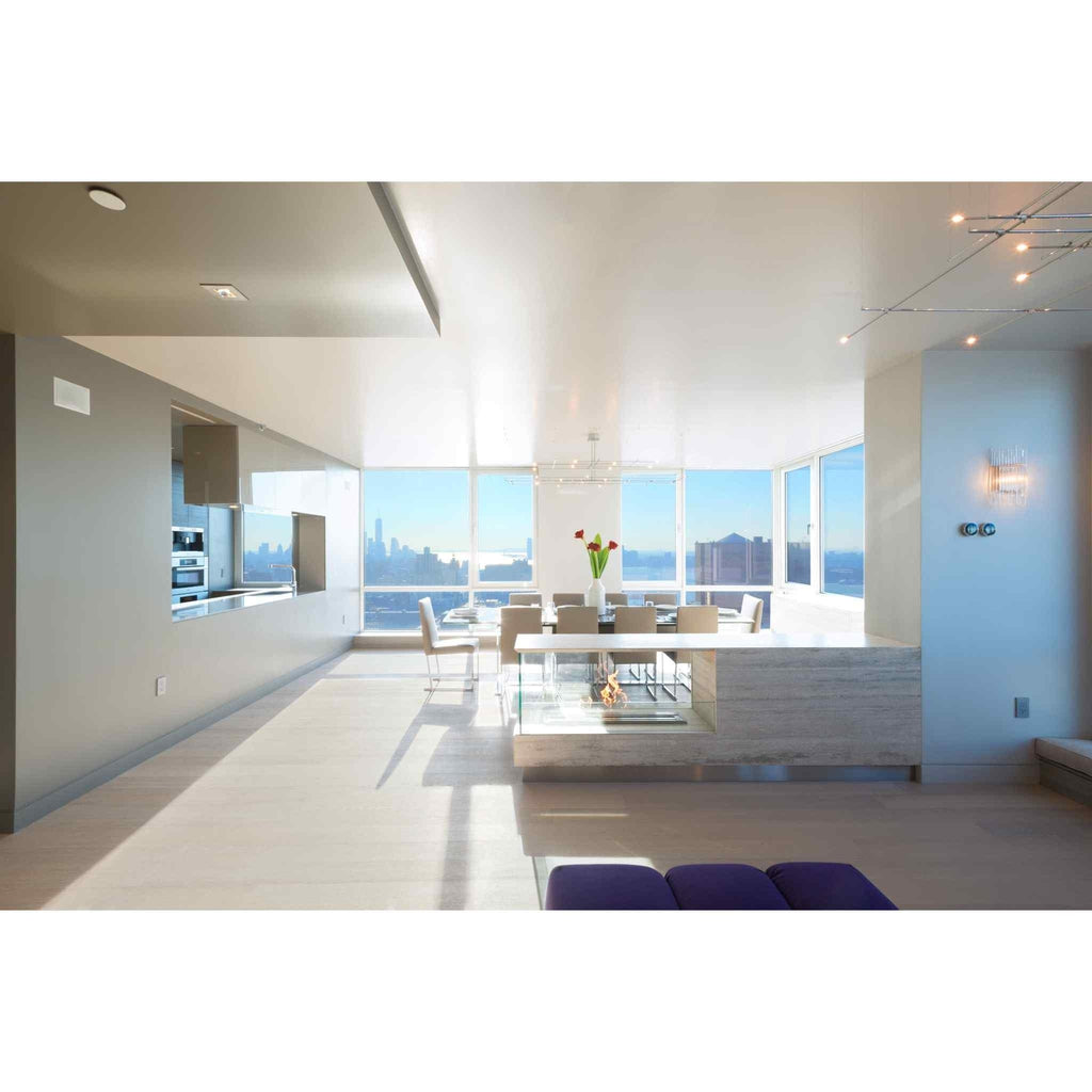 EcoSmart Fire XL900 ethanol burner integrated into a modern stone-topped console in a bright, open-plan apartment.