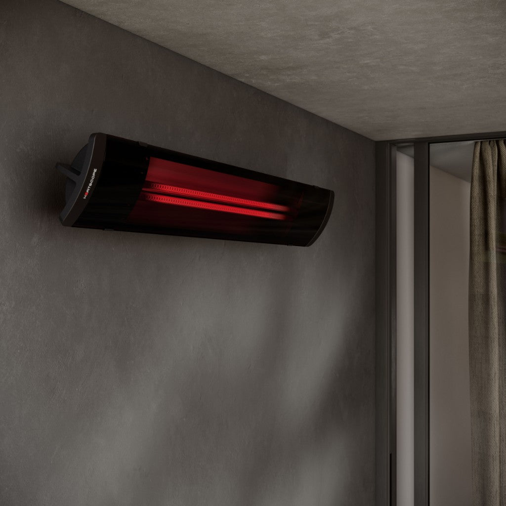 Heatscope Heaters Pure 2400W electric radiant heater in black, mounted on a grey wall with a glowing red element.
