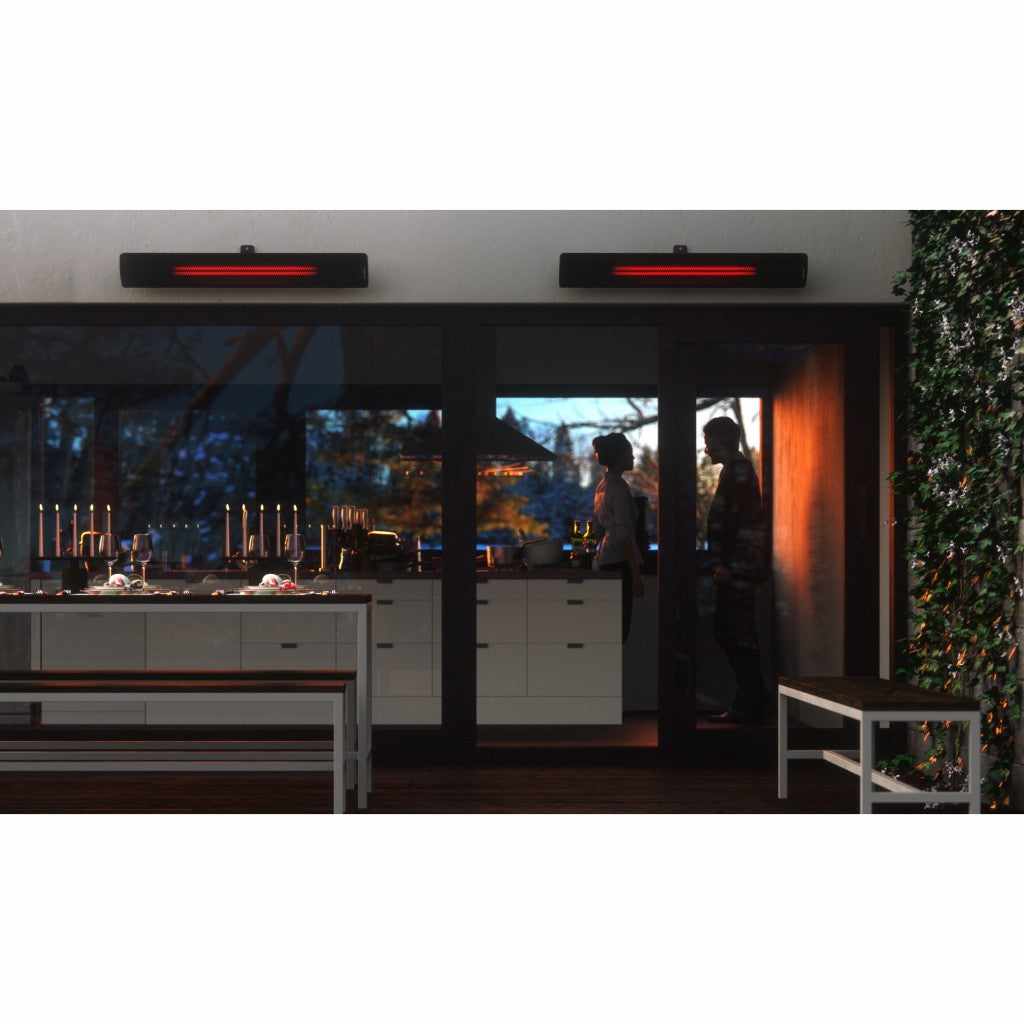 Two black Heatscope Heaters Pure 3000W mounted on a wall above a modern outdoor dining area at night.