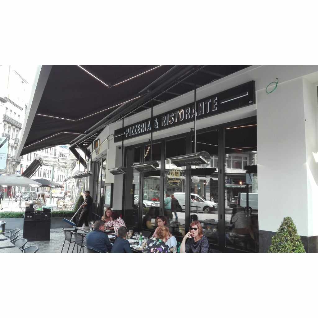Heatscope Heaters Spot 1600W electric radiant heaters mounted under a black awning at an outdoor pizzeria terrace.