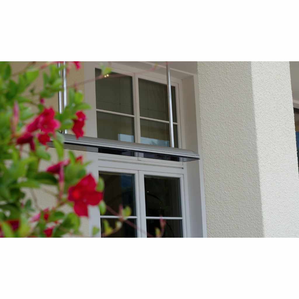 Heatscope Heaters Vision 3200w electric radiant heater mounted on a white wall above a window, partially obscured by flowers.
