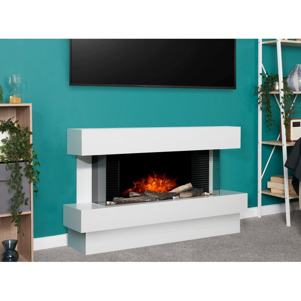 Manola XLS Electric Suite Fireplace in white with a wide, three-sided glass fire display against a teal wall.