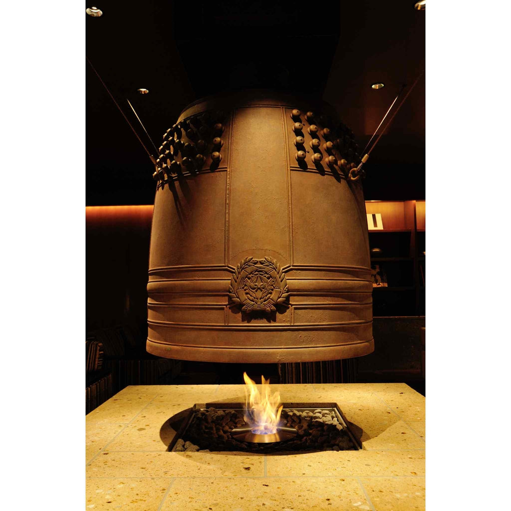 EcoSmart Fire AB8 Ethanol Burner with top tray set in a stone table beneath a large, suspended bronze bell fireplace.