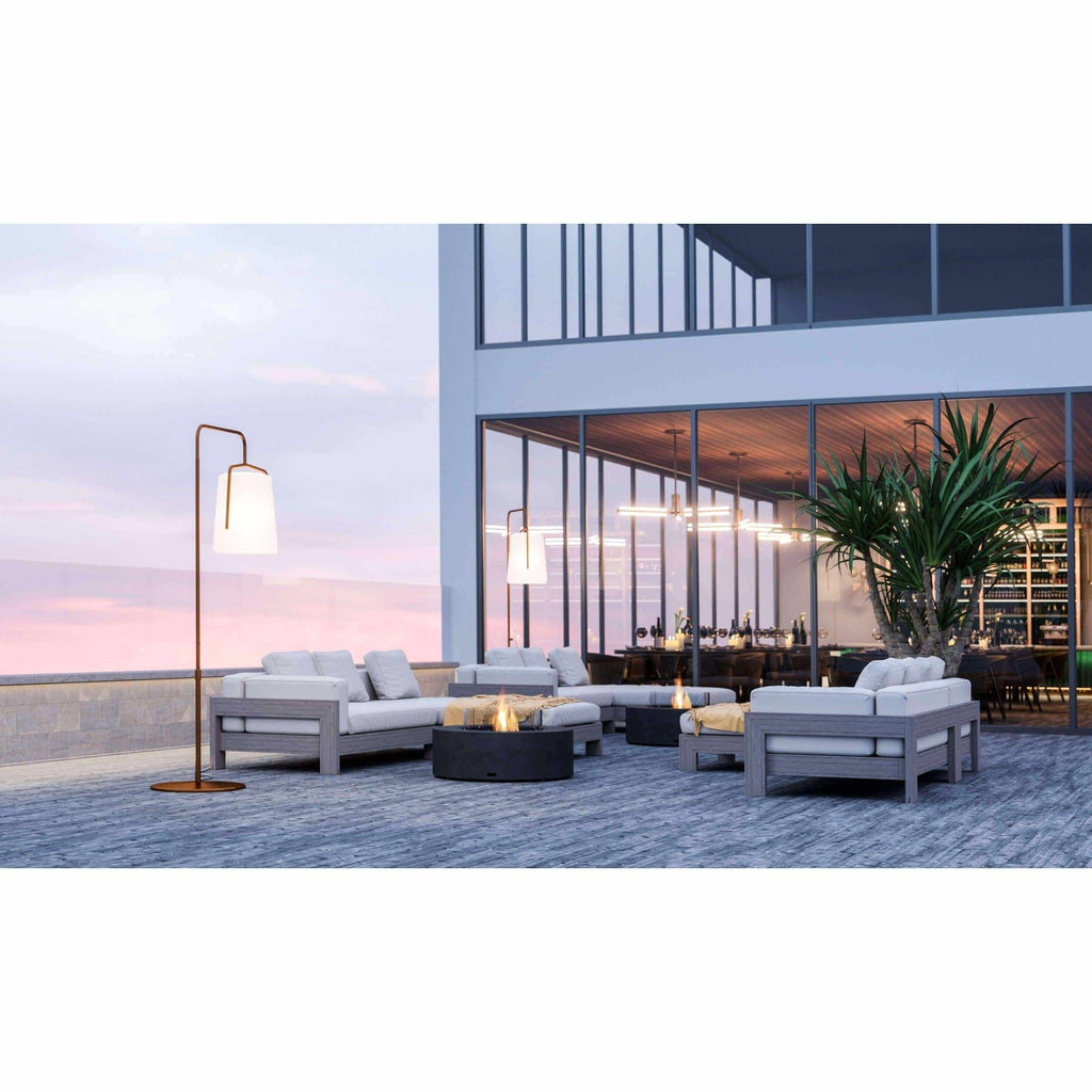 EcoSmart Fire Ark 40 bioethanol fire pit table in black, positioned between grey outdoor sofas on a modern terrace.