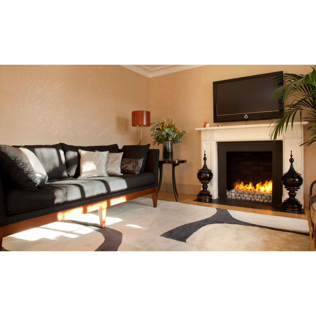 EcoSmart Fire XL700 ethanol burner with glowing flames and decorative stones inside a white fireplace surround.