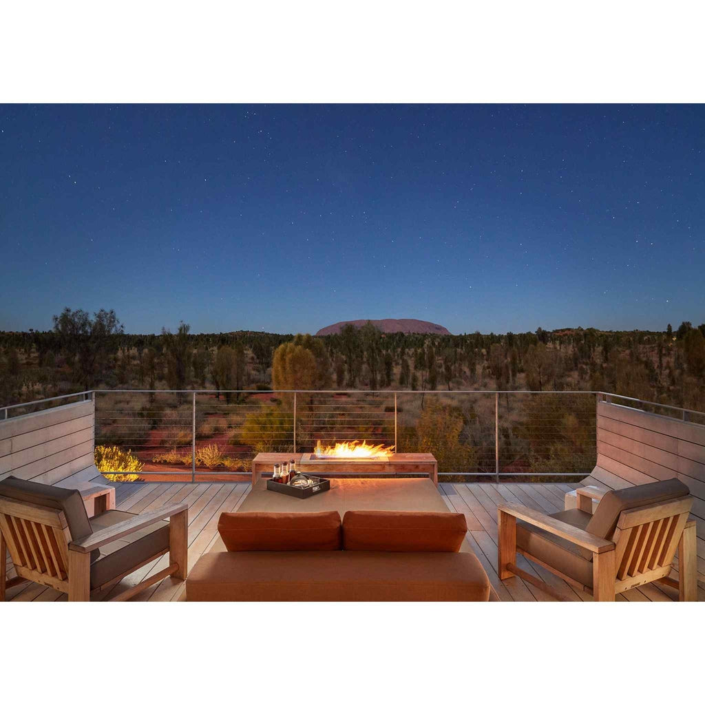 EcoSmart Fire XL700 ethanol burner glowing on a wooden deck overlooking a desert landscape at twilight.