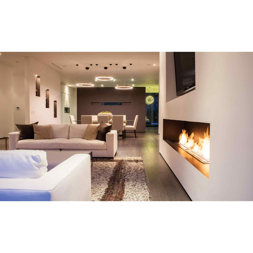 EcoSmart Fire XL900 ethanol burner integrated into a modern white wall with a linear flame in a contemporary living room.