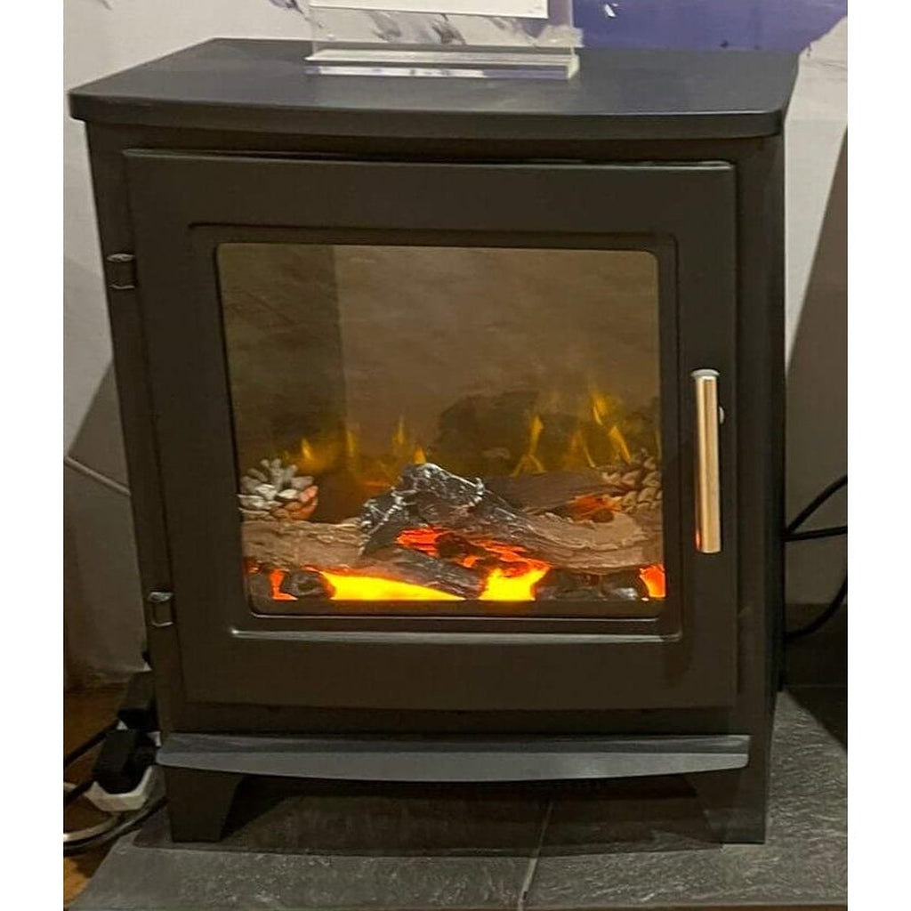 Flametek Milo electric stove in matte black with a glass door, log fuel bed, and glowing orange flame effect.